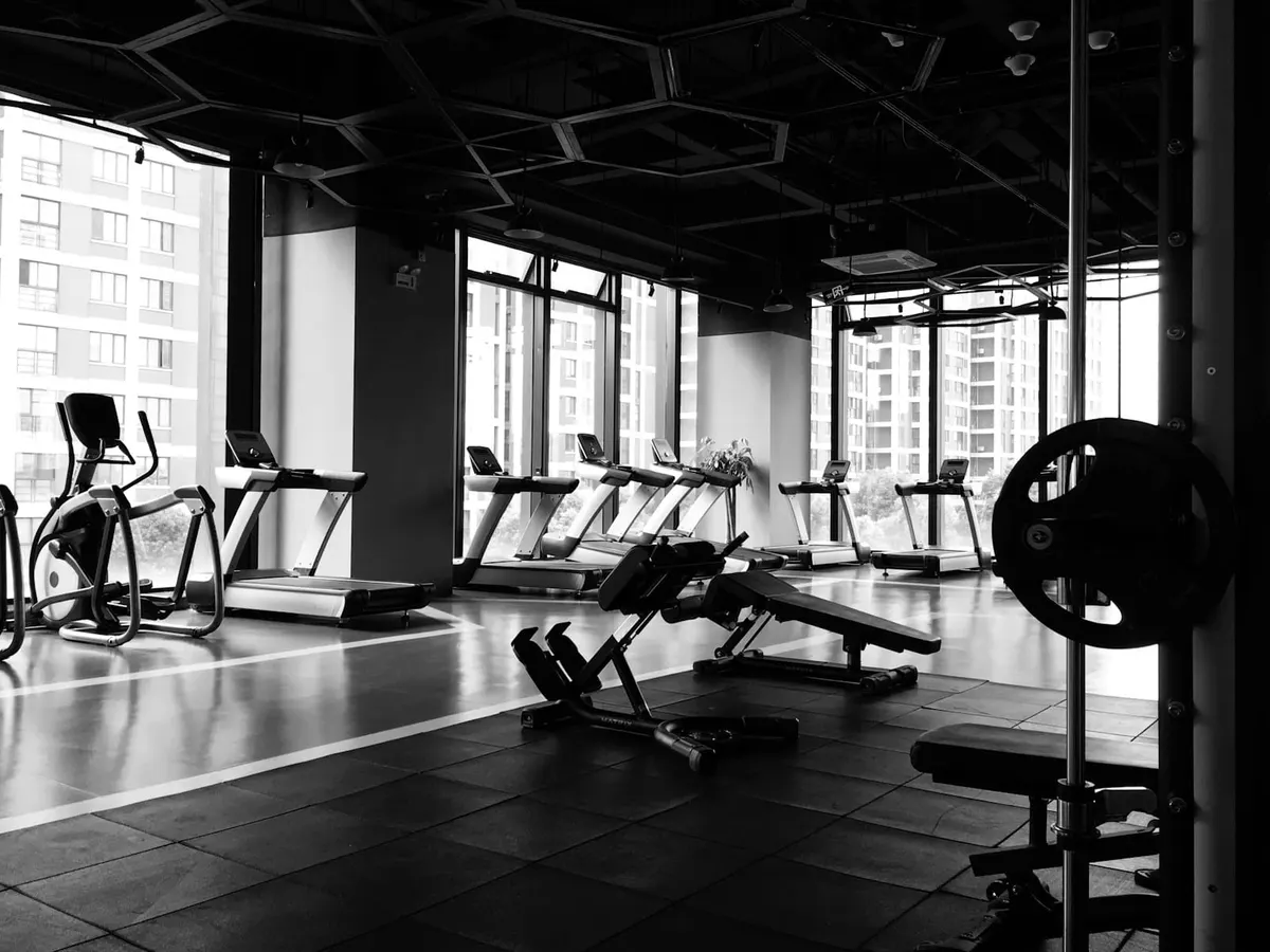 Fitnessstudio mit Trainingsgeräten und großen Fenstern